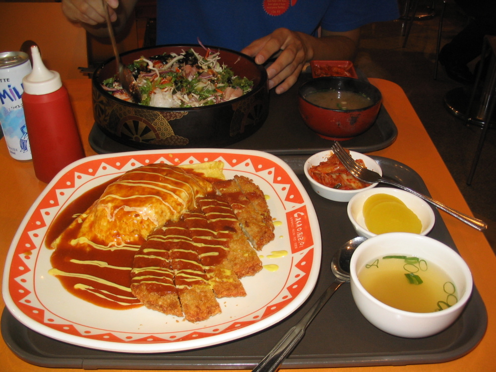Seoul, Korea :: Here is a meal from one of my favorite places in Seoul at the World Cup Mall. It's also Tonkatsu, or in Korea Dunkasu, with a tomato sauce on top. The egg is an omellete filled with rice (quite popular in Korea) and of course there is kimchi. My friend was eating some sort of sushi salad. The drink "Milkis" is a carbonated milk drink, actually really good. 