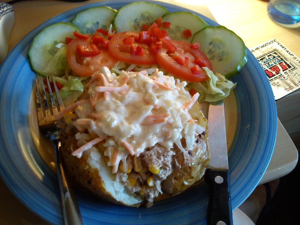 manchester u.k :: jacket potato filled with tuna, sweetcorn and colslaw, served with salad