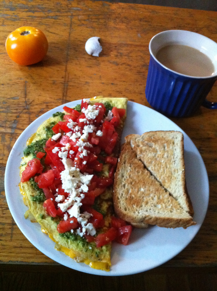 Brookline, MA :: Cage free eggs, Parker Farm tomatoes, feta, homemade pesto; red peppers, red onion, and sharp chedder in the inside. Cast iron. A dash of kosher salt and fresh ground black pepper. Freshly ground Trader Joe's peaberry coffee. Gone in a minute.