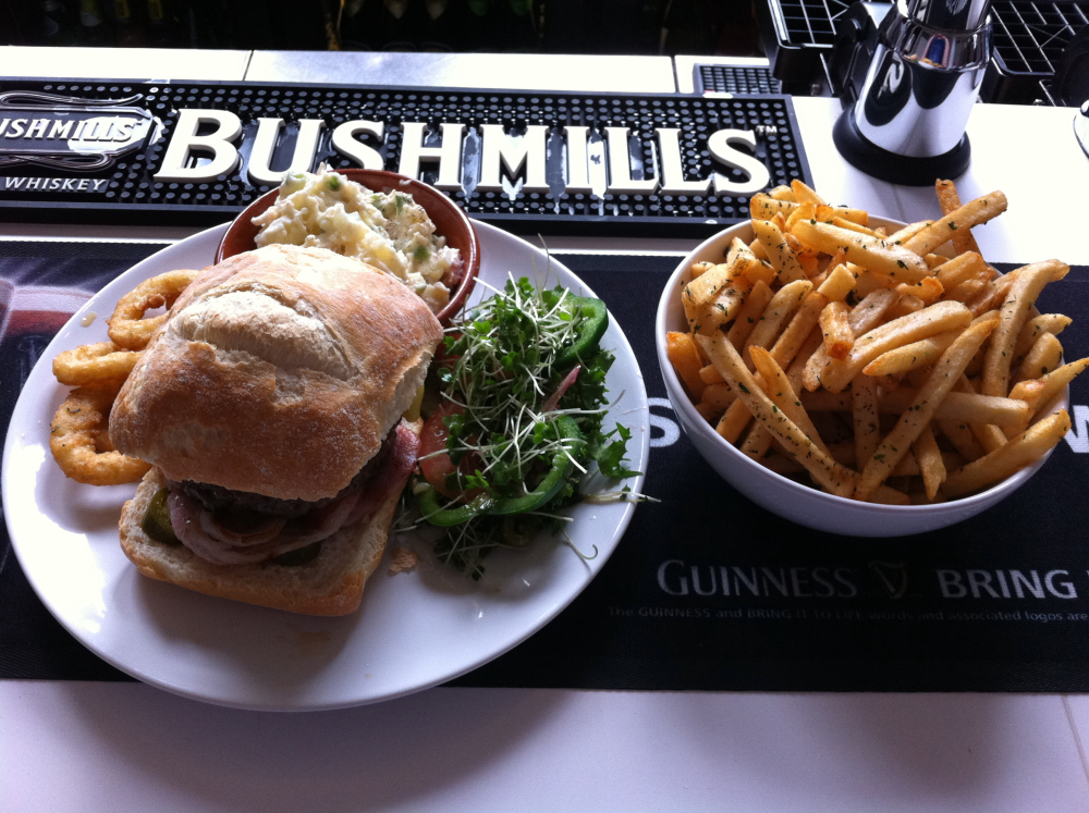 TheBoardroom, Wilmslow :: Beef burger w/ English bacon and English cheddar, mixed greens, onions rings, chips, and chefs potatoe salad. Yeah. I ate that. 