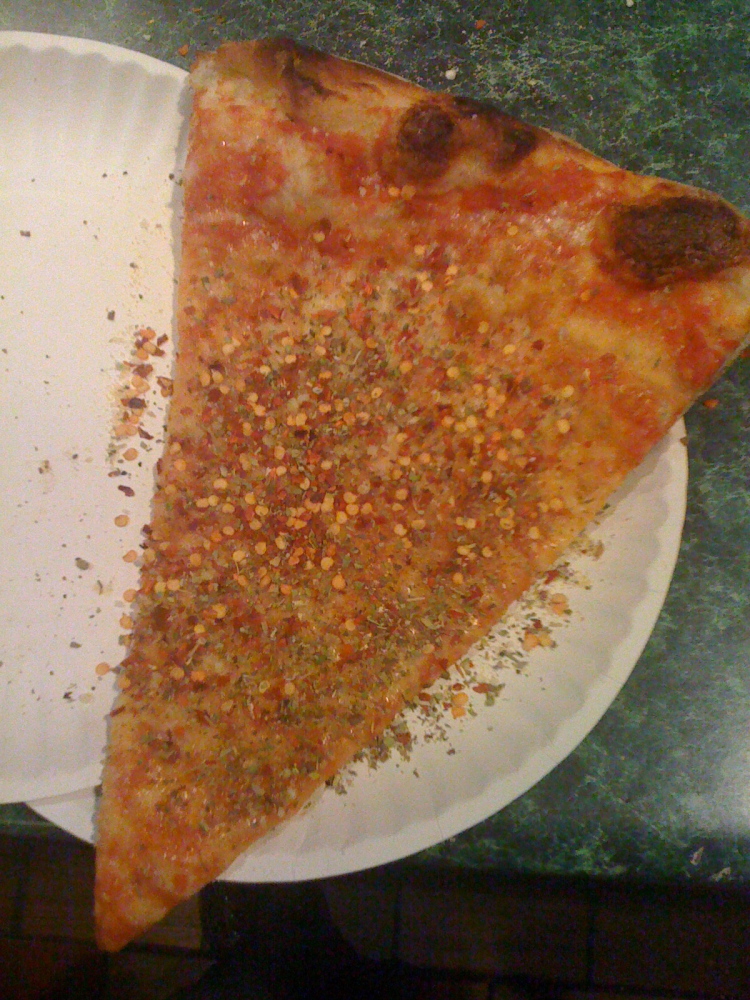 NYC :: pizza with loads of hot pepper flakes on it!  