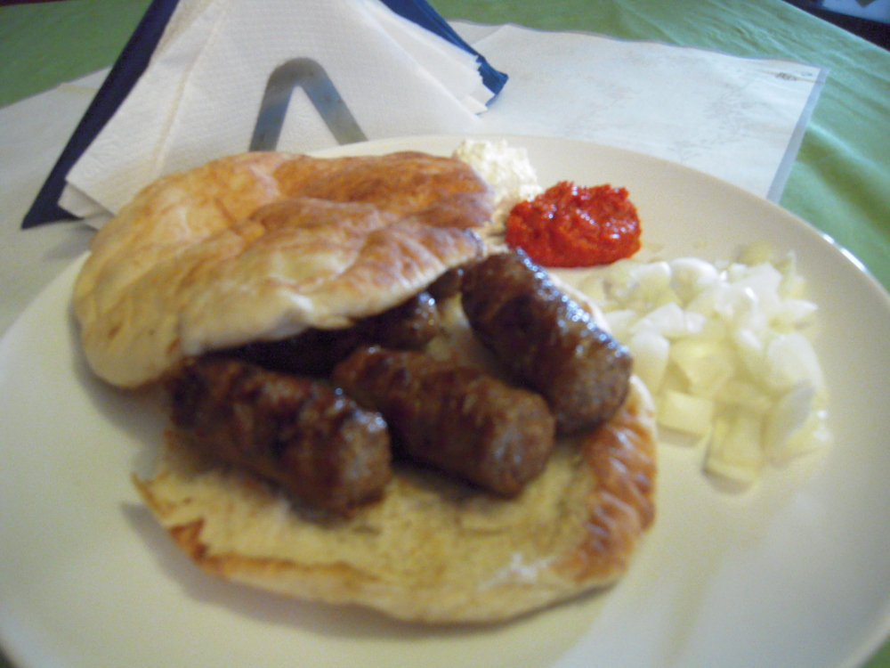 Queens, NY :: Cevapi - a Bosnian dish consisting of small  grilled beef sausages served with  lepina and chopped onion on the  side.

It's kinda awkward, because how are you supposed to eat it like a cheeseburger when the sausages will just fall out? Answer: You can't! You have to cut it up with a fork and knife..

Needless to say, it was Awesome!